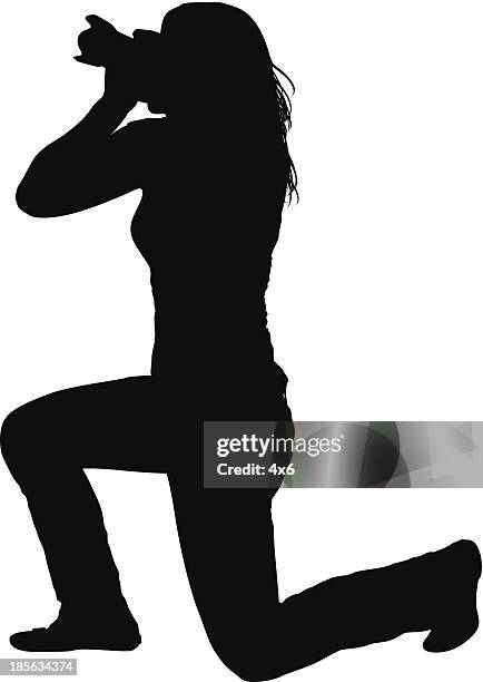 stockillustraties, clipart, cartoons en iconen met silhouette of woman holding camera - woman kneeling