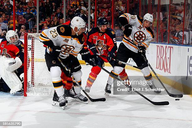 Brian Campbell of the Florida Panthers tangles with Chris Kelly of the Boston Bruins and teammate Jordan Caron at the BB&T Center on October 17, 2013...