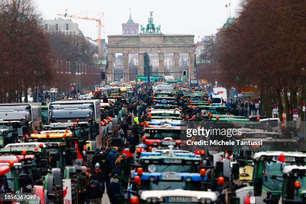 Farmers arrive on their tractors at the Brandenburg Gate to protest against planned cuts to state subsidies that bring down their fuel costs on...