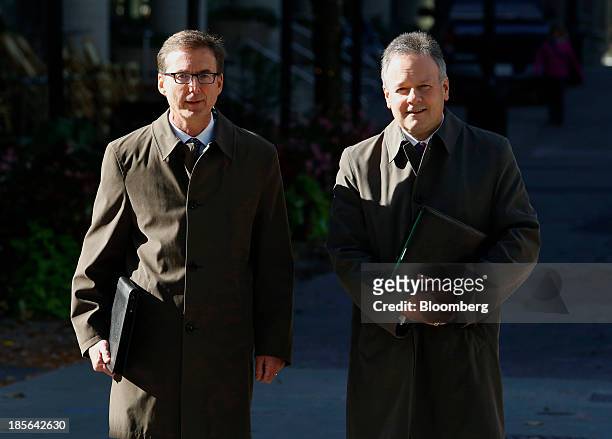 Stephen Poloz, governor of the Bank of Canada, right, and Tiff Macklem, senior deputy governor of the Bank of Canada, wait to cross Bank Street...