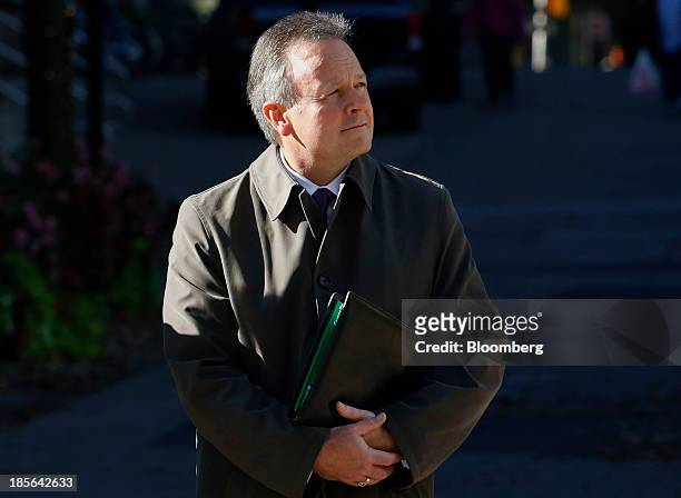 Stephen Poloz, governor of the Bank of Canada, waits to cross Bank Street before arriving at a news conference in Ottawa, Ontario, Canada, on...