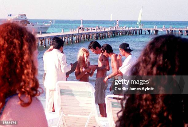 Pamela Anderson and Tommy Lee get married February 19, 1995 on the beach in Cancun, Mexico as fans watch nearby.