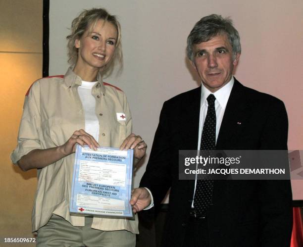 La mannequin slovaque Adriana Karembeu présente le 17 octobre 2000 à Paris, le diplôme de "formation aux premiers secours" que vient de lui remettre...