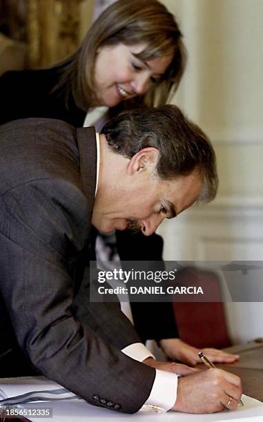 Colombian President Andres Pastrana signs a book that was given to him by the Deputy Mayor of Buenos Aires, Cecilia Felgueras , 13 October 2000....