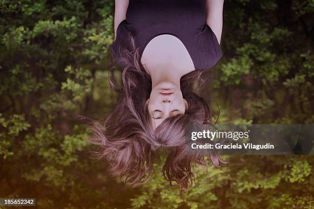 girl upside down with hair flying and eyes closed - auf-den-kopf-gestellt stock-fotos und bilder