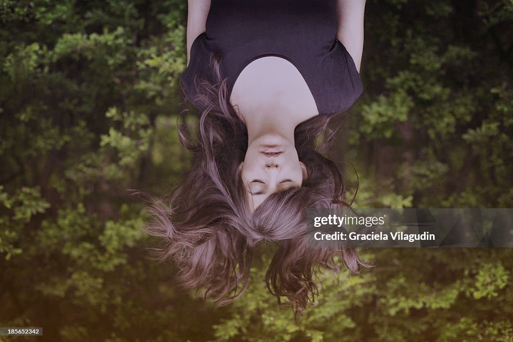 Girl upside down with hair flying and eyes closed