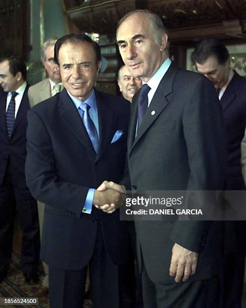 The President of Argentina, Fernando de la Rua poses for photographers with former president Carlos Menem, 22 September 2000, in the president's...