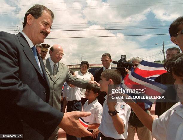 Mexican President-elect Vicente Fox greets children 12 September 2000 at the entrance of the Institute of Biodiversity in Santo Domingo, Heredia,...