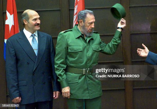 Cuban President Fidel Castro , next to President of Republic of Belarus, Alexander Lukashenko , takes off his cap during the meeting at the Council...