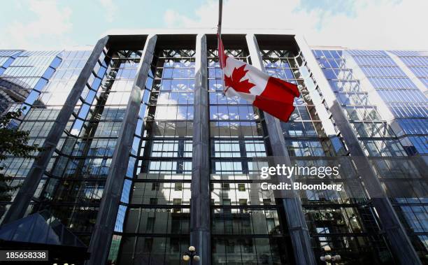 The Canadian flag flies outside the Bank of Canada building in Ottawa, Ontario, Canada, on Wednesday, Oct. 23, 2013. Bank of Canada Governor Stephen...