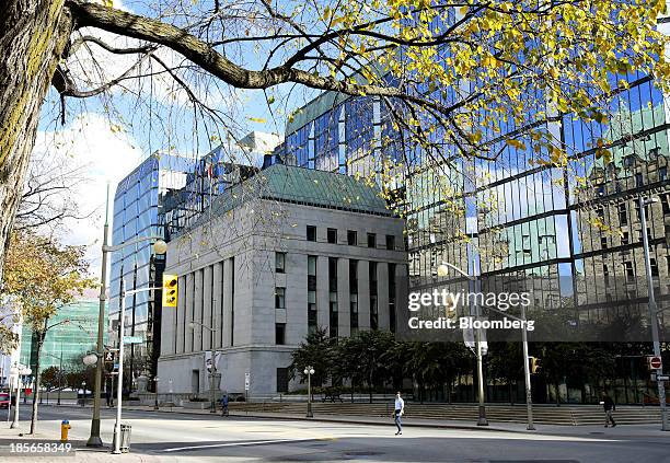 Pedestrians pass in front of the Bank of Canada building in Ottawa, Ontario, Canada, on Wednesday, Oct. 23, 2013. Bank of Canada Governor Stephen...