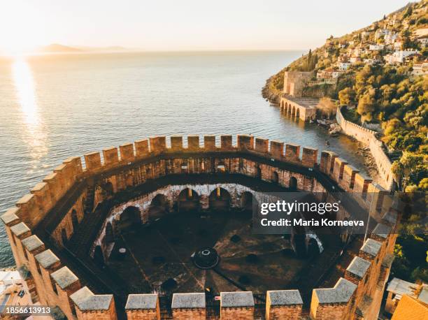 red tower and old walls of the alanya fortress, antalya turkey. - alanya castle stock pictures, royalty-free photos & images