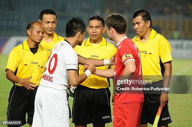 Michael Owen shakes hand with Bambang Pamungkas before kick off in the friendly match between Indonesia Red and the Manchester United Legends on...