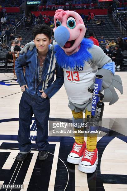 Rich Brian poses for a photo with Chuck the Condor prior to a basketball game between the Los Angeles Clippers and the Golden State Warriors at...