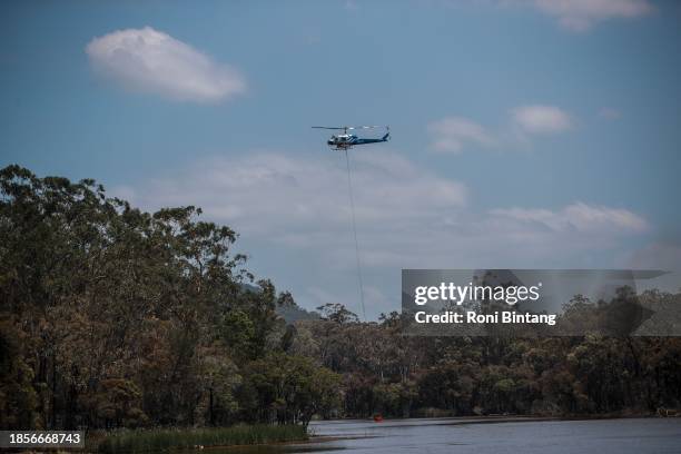 Water bombing helicopter resupplies on December 15, 2023 in the Hunter Valley, Australia. Several fast-moving bushfires prompted evacuations and...