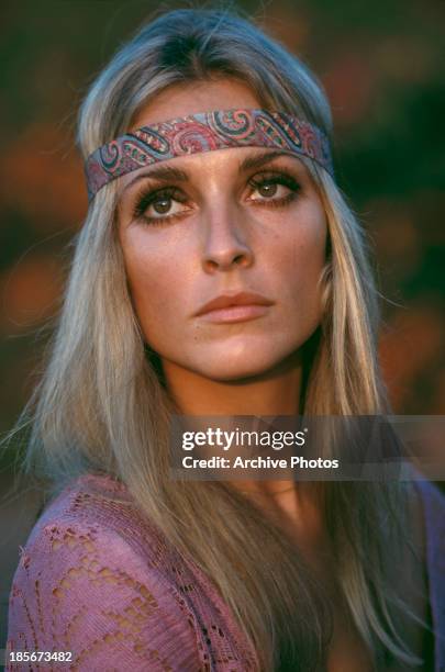 American actress Sharon Tate wearing a pink top and headband, circa 1968.