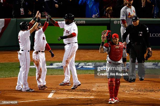 David Ortiz of the Boston Red Sox celebrates with Dustin Pedroia and Jacoby Ellsbury after scoring on a hit by Mike Napoli in the first inning...