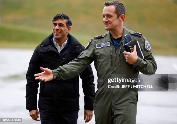 Britain's Prime Minister Rishi Sunak walks with Station Commander Group Captain Jim Lee as he arrives to visit Royal Air Force base Lossiemouth in...