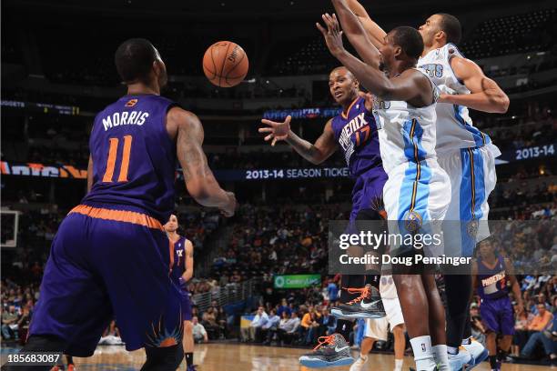 Tucker of the Phoenix Suns passes the ball to teammate Markieff Morris of the Phoenix Suns against the defense of Jordan Hamilton of the Denver...