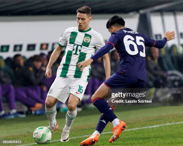 Fabiano Parisi of ACF Fiorentina challenges Kristoffer Zachariassen of Ferencvarosi TC during the UEFA Europa Conference League match between...