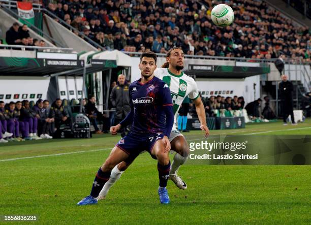Cebrails Makreckis of Ferencvarosi TC competes for the ball with Josip Brekalo of ACF Fiorentina during the UEFA Europa Conference League match...