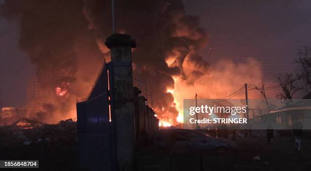 This image grab taken from AFPTV video footage on December 18, 2023 shows flames from the fire at Conakry's main fuel depot . At least eight people...