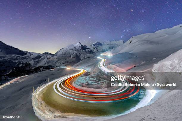 car trail lights on snowy mountain road - central europe stock pictures, royalty-free photos & images