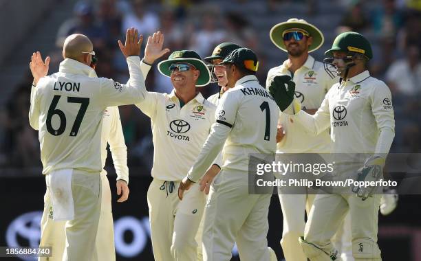 David Warner of Australia celebrates with Nathan Lyon after catching Abdullah Shafique during day two of the Men's First Test match between Australia...