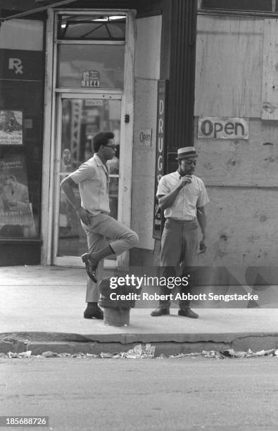 View of two man standing and speaking to each other on a street, Chicago, Illinois, mid 1960s.