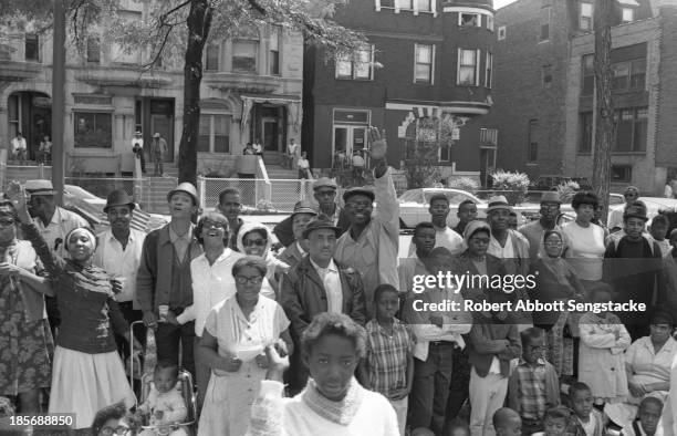 View showing the crowds lined up along the street to watch the Bud Billiken Day parade, Chicago, Illinois, mid to late 1960s .