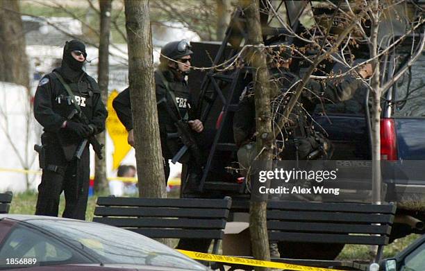 Agents with combat gears stand by a vehicle during a standoff with Dwight Watson, a former military policeman of North Carolina, who drove his...