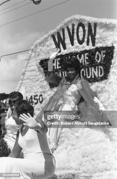 View showing women riding on the float sponsored by the WVON radio station, during the Bud Billiken Day parade, Chicago, Illinois, mid to late 1960s...