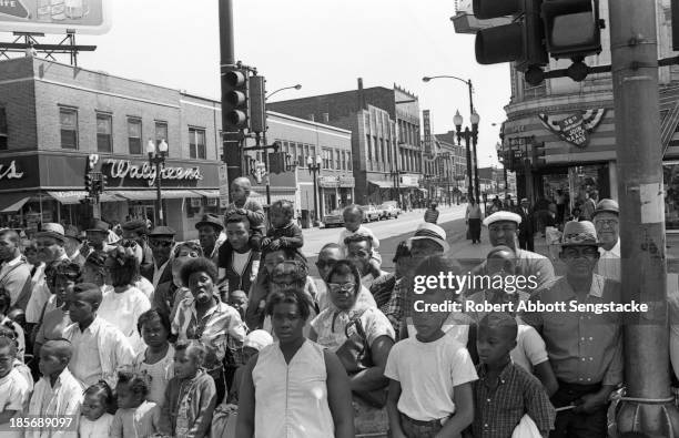 View showing the crowds lined up along the street to watch the Bud Billiken Day parade, Chicago, Illinois, mid to late 1960s .