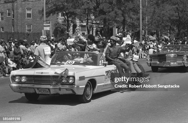 Group of young adults hold up signs that read 'Black Power' while riding in an open convertible during the Bud Billiken Day parade, Chicago,...