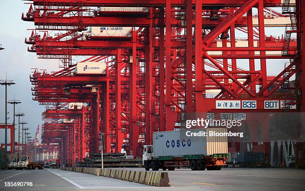 Truck carrying a China Cosco Holdings Co. Shipping container drives past cranes at the Yangshan Deep Water Port, part of China Pilot Free Trade...