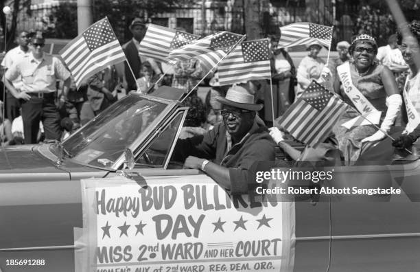 Miss 2nd Ward and her court smile and wave while riding in a convertible during the Bud Billiken Day parade, Chicago, Illinois, mid to late 1960s .
