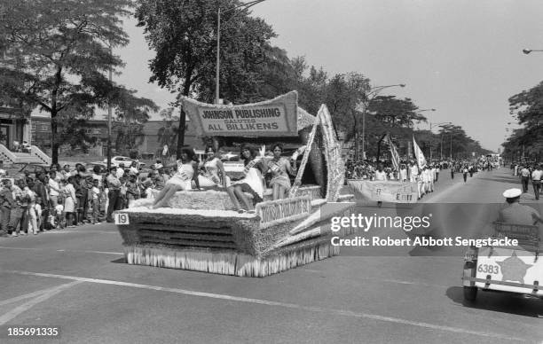 View of Miss Jet, Miss Negro Digest, Miss Ebony, and Miss Tan as they ride on the Johnson Publishing float, as it travels along the Bud Billiken Day...