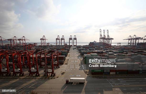 Truck carrying a shipping container drives through the Yangshan Deep Water Port, part of China Pilot Free Trade Zone's Yangshan free trade port area,...