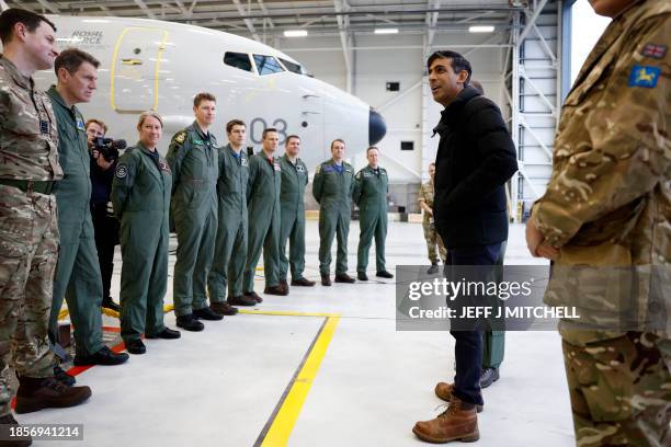 Britain's Prime Minister Rishi Sunak meets with RAF military personnel in an aircraft hangar during his visit to Royal Air Force base Lossiemouth in...