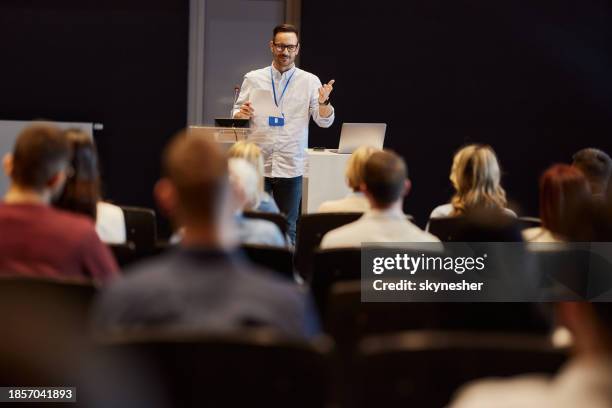 happy public speaker talking on a conference at convention center. - presskonferens bildbanksfoton och bilder