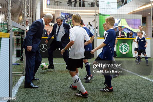 President Michel Platini and former German national player Franz Beckenbauer play football with children prior to the DFB Bundestag at the NCC...