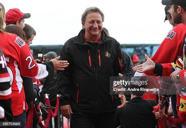 Ottawa Senators owner Eugene Melnyk high-fives fans as he walks down the red carpet before the home opener against the New Jersey Devils at Canadian...