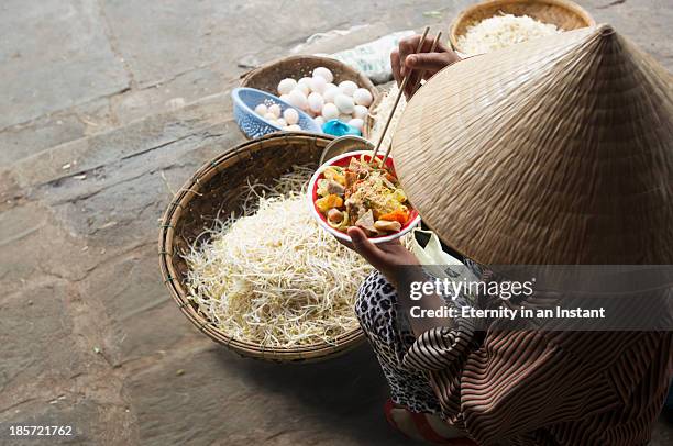 woman eating noodles with baskets of produce - adult eating no face stock pictures, royalty-free photos & images