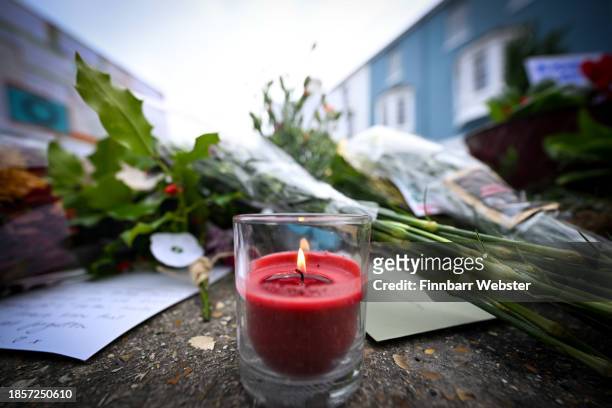 Candle is placed with the flowers at the vigil for the deceased asylum seeker, outside Portland Port, on December 15, 2023 in Portland, England....