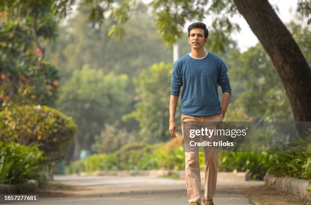 men walking in garden - hands in pockets stock pictures, royalty-free photos & images