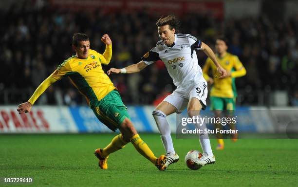Swansea player Michu beats Artem Fidler to the ball during the UEFA Europa League Group A match between Swansea City and FC Kuban Krasnodar at...