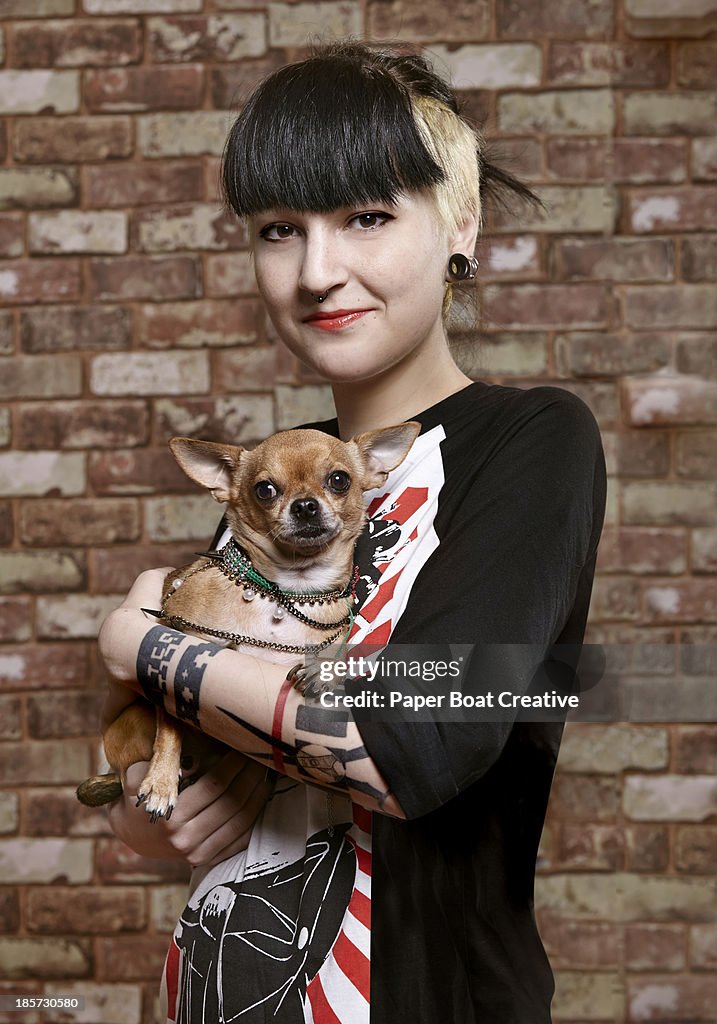 Young trendy student holding her pet dog