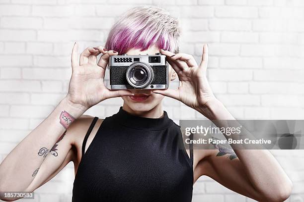 hip young lady taking a photo with her film camera - in front of camera stock pictures, royalty-free photos & images