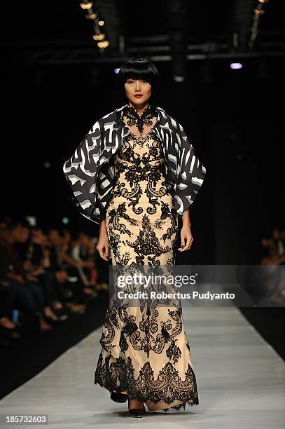 Model showcases designs by Albert Yanuar on the runway at the Enlightenment show during Jakarta Fashion Week 2014 at Senayan City on October 24, 2013...