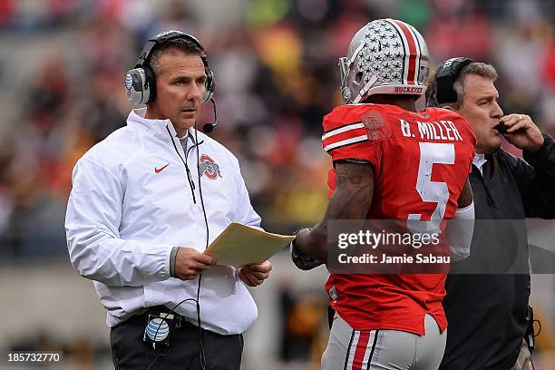 Head Coach Urban Meyer of the Ohio State Buckeyes on the sidelines with quarterback Braxton Miller of the Ohio State Buckeyes during game against the...